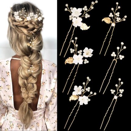 Close-up of 6 ornate gold leaf and flower pearl bridal hair pins, scattered on a soft white background.