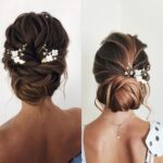 Close-up of 6 ornate gold leaf and flower pearl bridal hair pins, scattered on a soft white background.