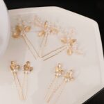 Close-up of 7 gold leaf and pearl wedding hair pins, showcasing intricate details and varying styles.