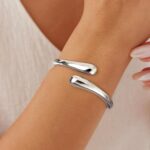 Close-up of an Eaciy 14K gold plated chunky twist cuff bangle bracelet with a polished silver finish.