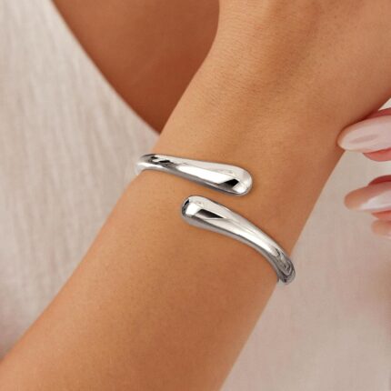 Close-up of an Eaciy 14K gold plated chunky twist cuff bangle bracelet with a polished silver finish.