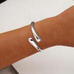 Close-up of an Eaciy 14K gold plated chunky twist cuff bangle bracelet with a polished silver finish.
