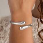 Close-up of an Eaciy 14K gold plated chunky twist cuff bangle bracelet with a polished silver finish.