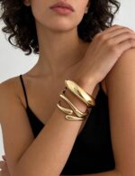 Three iF YOU 14K gold plated chunky bangle bracelets stacked together on a wrist, showing their round shape.