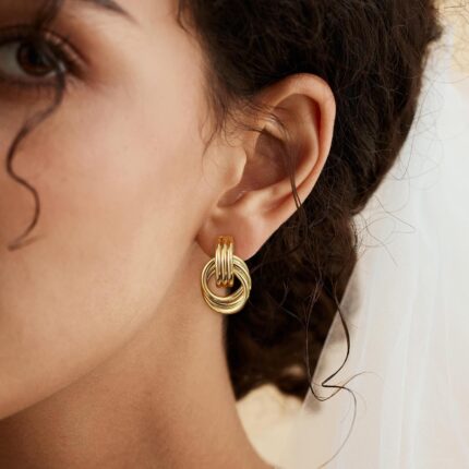 A pair of SHERLOVE Chunky Knot Gold Drop Earrings, 14K gold plated, showcasing their unique knot design and dangle style.