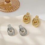 A pair of SHERLOVE Chunky Knot Gold Drop Earrings, 14K gold plated, showcasing their unique knot design and dangle style.
