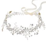 Close-up of a silver bridal headpiece featuring delicate metal leaves, luminous pearls, and sparkling clear rhinestones.