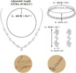Close-up of a silver-plated necklace and matching earrings adorned with clear round rhinestones, presented in a gift box.